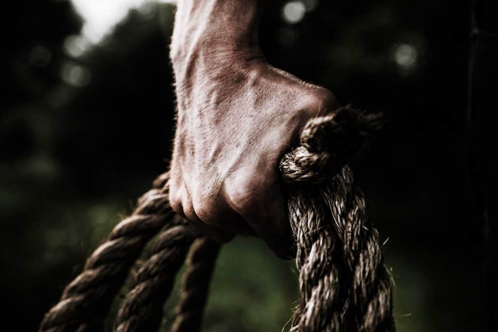 Man Holding Brown Rope Showing Strength
